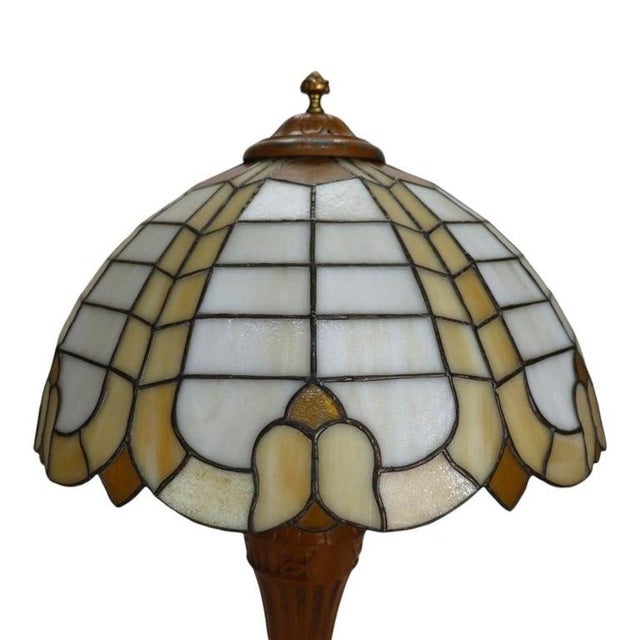 This antique table lamp features a stained and leaded glass shade, characteristic of the Bradley & Hubbard quality, dating...
