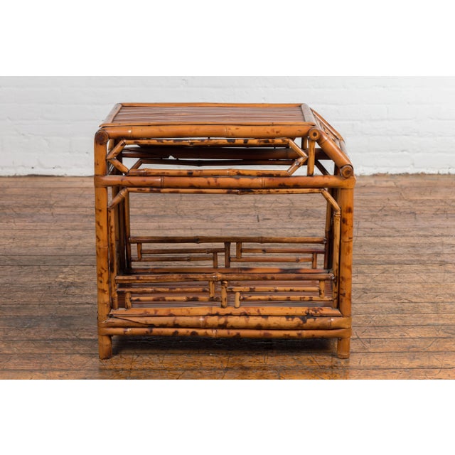 A vintage Chinese bamboo side table from the mid 20th century with fretwork motifs, natural stain finish. Exemplifying mid...