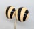 1980s round domed goldtone black and ivory enamel striped clip earrings. Marked "CINER®" on the clips and "CINER©" on the...