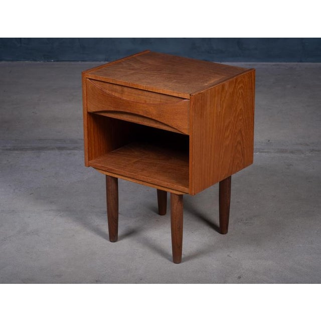 Elegant and rarely seen bedside or side table designed by Niels Clausen in the 1960s. Crafted in teak with clean...