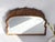 Antique half moon scalloped mirror made out of wood with a carved floral ornament on the top. The mirror has a nice wooden...