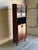 Upper leaded stained glass doors open to reveal display shelving over an open nook and lower solid doors. Round tapered...
