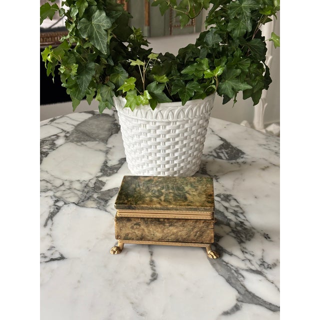 A beautifully hand crafted Italian alabaster box set in a beaded brass frame, resting on paw feet. The hinged lid opens to...