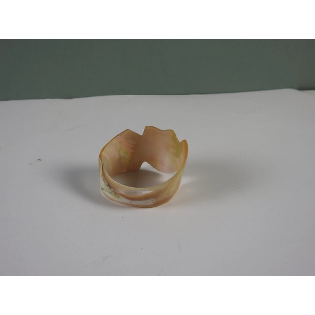 Carved shell mother of pearl napkin ring circa 1910. Carving of a horse shoe, lots of iridescence.