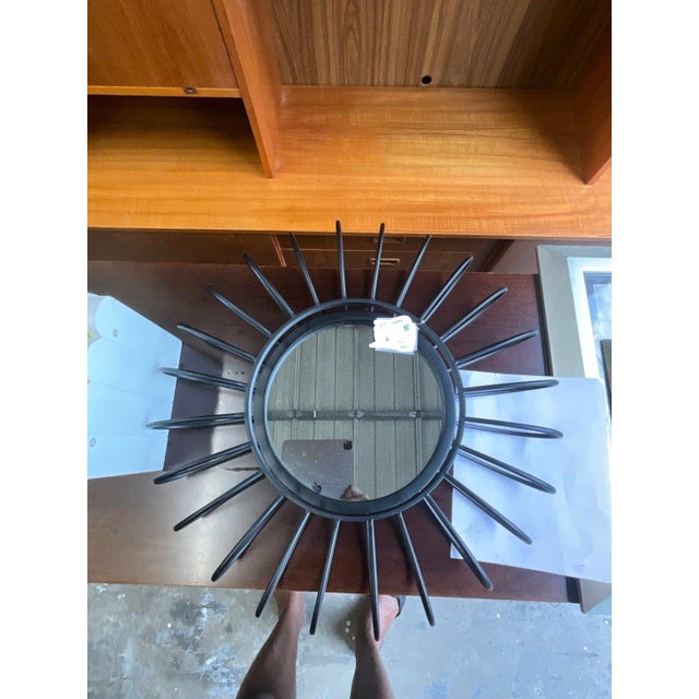 Graphic, sculptural, and sharp against light walls, this black sunburst round wall mirror works well as a functional or...