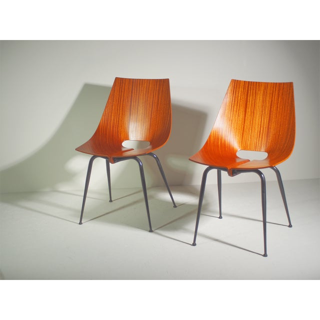 Set of two chairs with a black lacquered metal frame and curved teak seats. Original Italian mid-century modern...