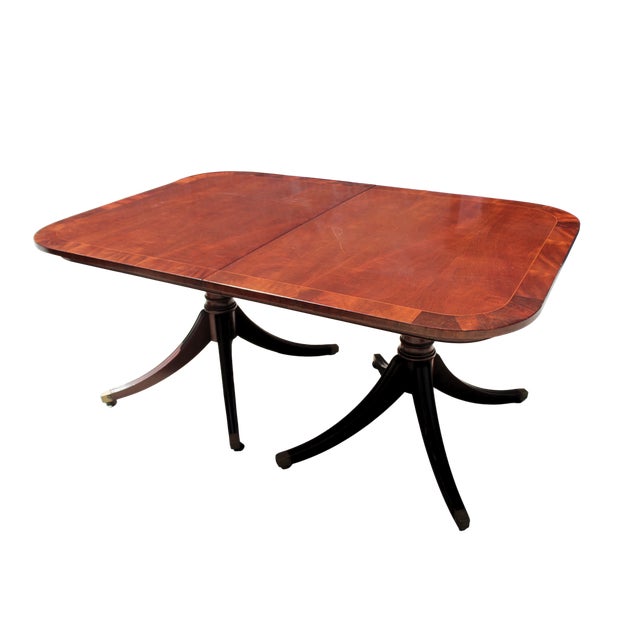 Elegant antique Duncan Phyfe-style dining table crafted in rich mahogany with a classic double-pedestal base terminating...