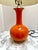 Vintage orange table lamp with tan linen style lamp shade. Fun pop of color in any room or decor.