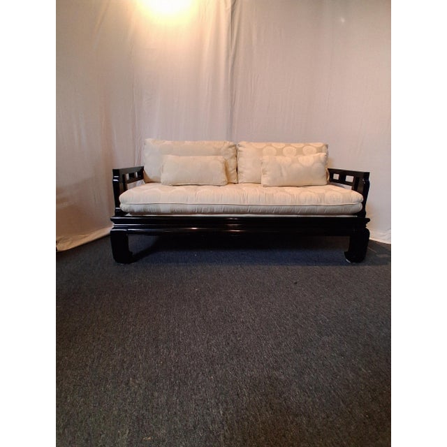 Elegant vintage Chinoiserie sofa or daybed featuring a glossy black lacquered wood frame, low platform base, dramatic...
