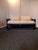 Elegant vintage Chinoiserie sofa or daybed featuring a glossy black lacquered wood frame, low platform base, dramatic...