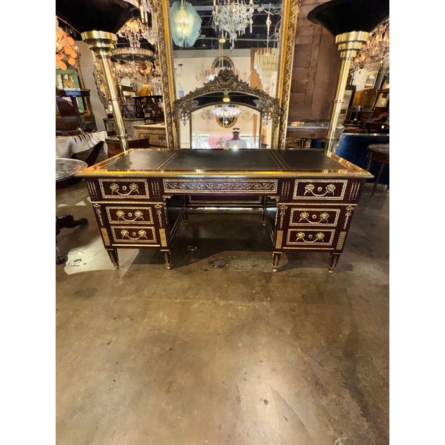 The Louis XVI Style Mahogany and Gilt Bronze Bureau Plat is an antique desk with a classic and elegant design. Made of...