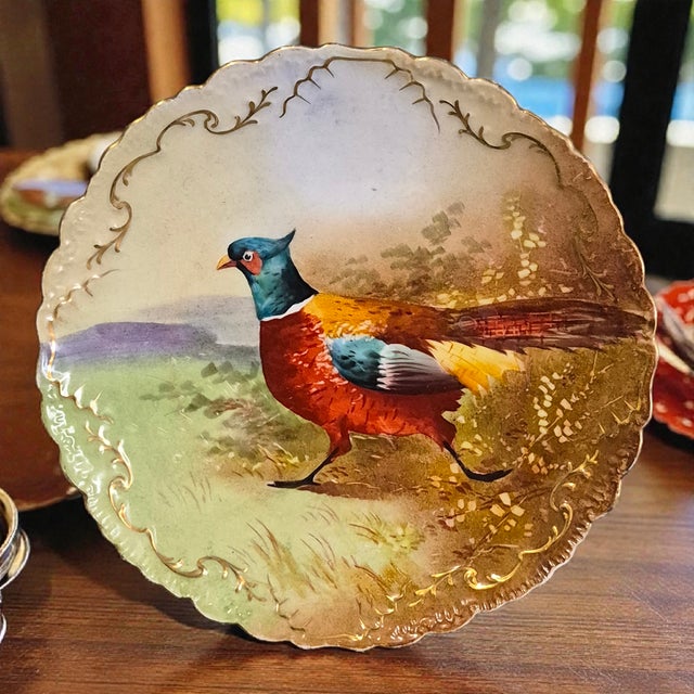 The Antique Limoges French Hand Painted Pheasant Scalloped Edge Wall Plate is a beautifully crafted collector's item...