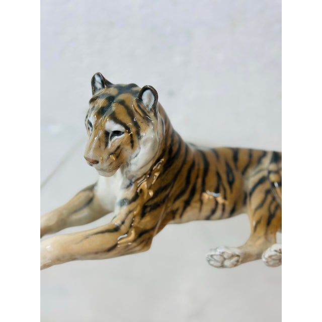 A finely detailed Royal Copenhagen porcelain tiger figurine, beautifully modeled in a reclining pose with hand-painted...