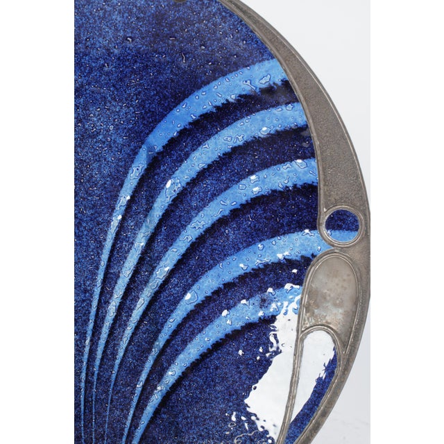 Art Nouveau pewter and enamel charger with a mottled cobalt-to-sky-blue fan/shell motif surface within a hammered pewter...