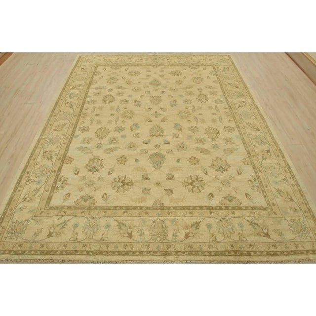 A traditional Ziegler rug hand-knotted with an all-wool pile on a cotton foundation. This oriental rug features muted...