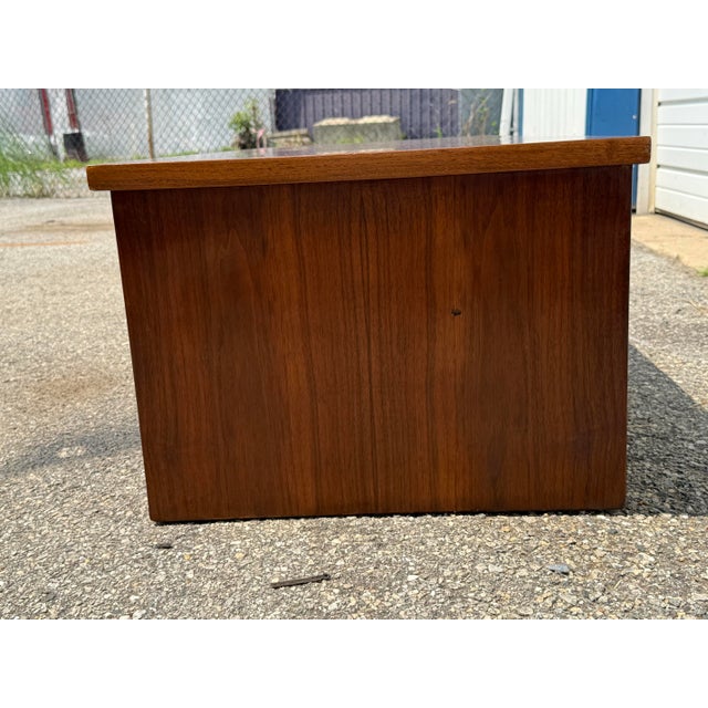 A handsome Mid-Century Modern low-profile walnut console featuring warm wood tones, clean architectural lines, and...