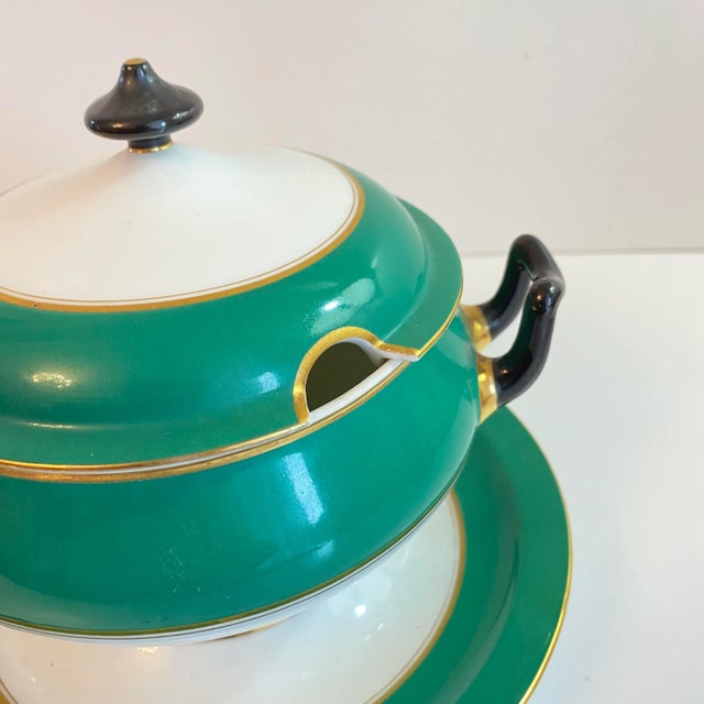 A striking vintage lidded sauce boat in crisp green and white porcelain with elegant gilded trim. The sculptural form,...