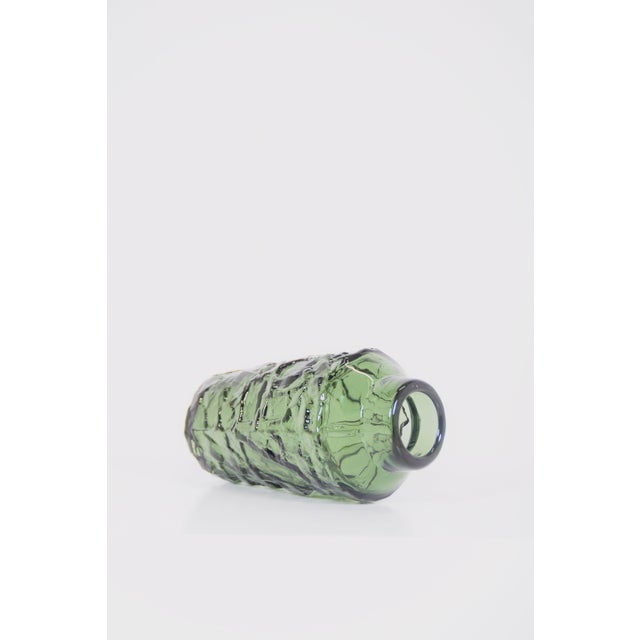 Swedish vase model Rustik designed by Göte Augustsson in the 1960s. It was manufactured in thick, green-tinted glass by...