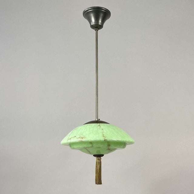 This Art Deco pendant was designed and manufactured in Germany in the 1930s. The light features a domed marbled glass...