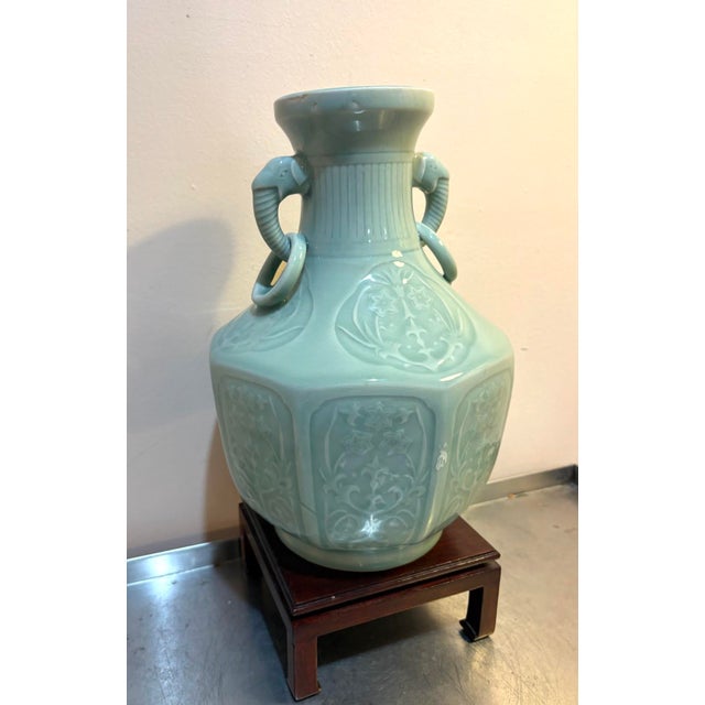 Early 20th-century Chinese celadon porcelain vase w/ elephant head detail at sides and wood stand. Excellent condition....