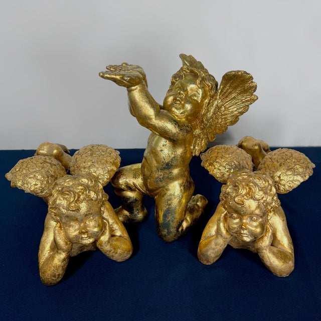 A striking trio of mid-century Hollywood Regency style cherub (putti) sculptures, ideal as a grand theatrical centerpiece...