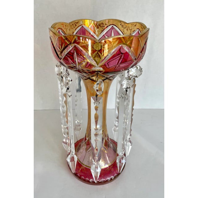Here is a stunning luster made with cut glass vase in ruby/raspberry and amber colors that is adorned with decadent...