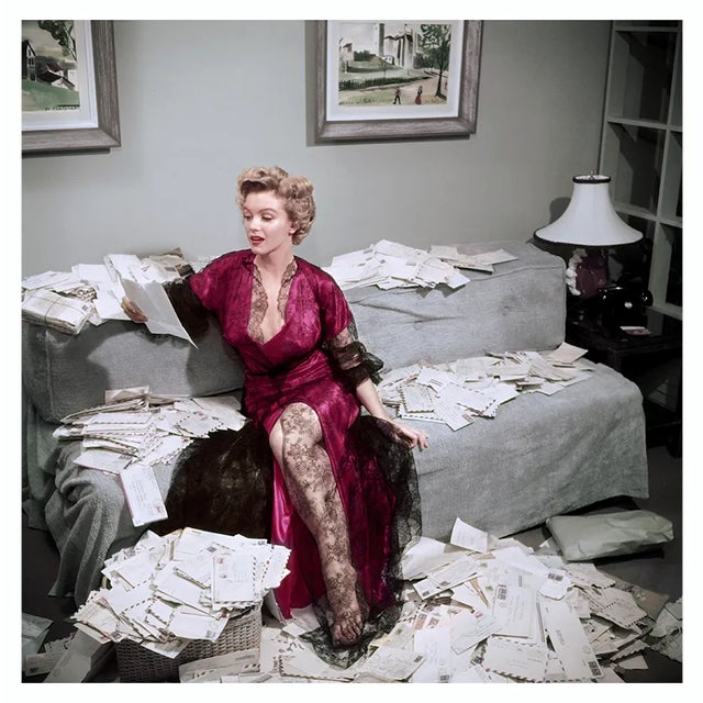 Fan Mail 1952 Marilyn Monroe (1926 – 1962), wearing a red negligee trimmed with black lace, sorts out her fan mail shortly...