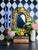 A giltwood wall mirror featuring an ornate Baroque Revival-inspired frame with bold scrolling ornament and an oval mirror...