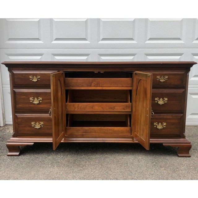 A traditional colonial style solid cherry long dresser with 9 dovetailed drawers and brass hardware by Pennsylvania House.