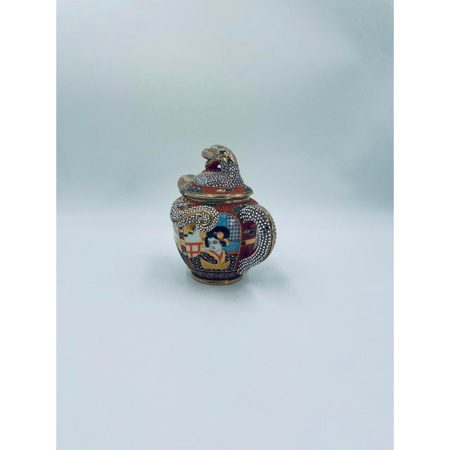 A milk jug produced in Japan between the 1930s and 1950s in the opulent Satsuma, Kutania style, crafted from high-quality,...
