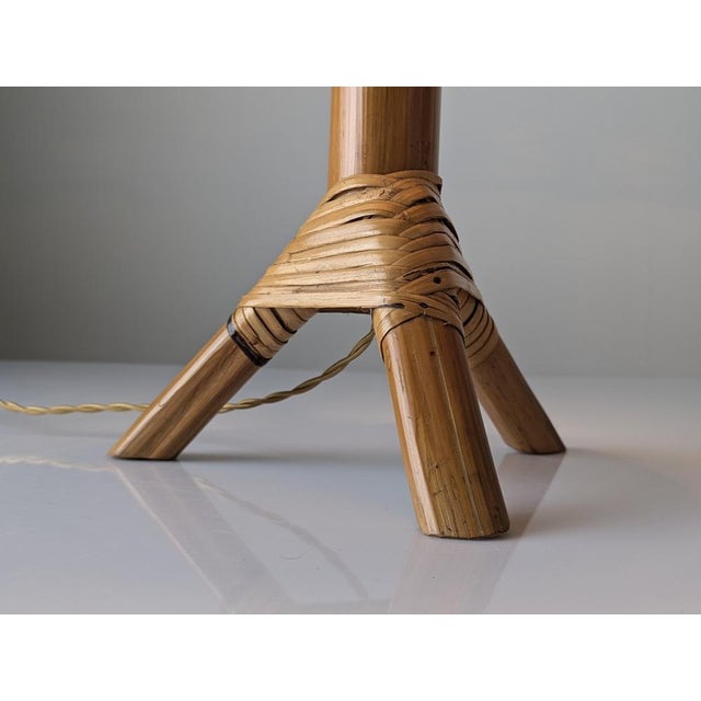 A mid-century handcrafted table lamp made of bamboo and rattan, dating from the 1950s. The piece is structured around a...