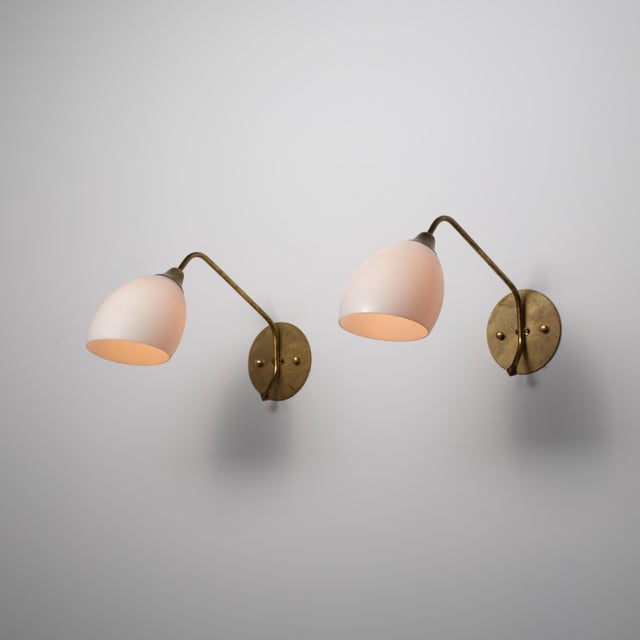 This pair of large Italian wall sconces from the 1950s combines softly curved opaline glass shades with slender brass arms...
