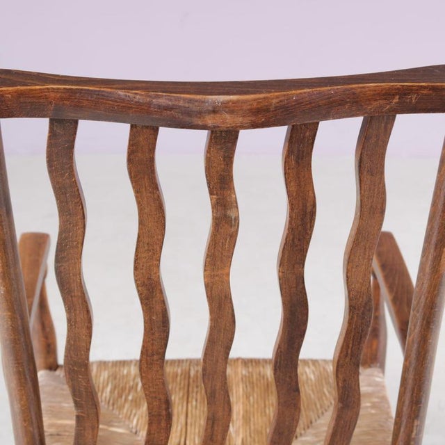 This charming 1930s low spindle-back hearth chair, attributed to the Arts & Crafts tradition and retailed by Liberty &...