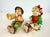 A charming matched pair of mid-century Japanese ceramic figurines depicting a seated boy playing a horn and a young girl...