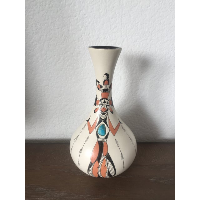 A small flared mouth vase by Raine, New Mexico, featuring a hand-painted Corn Maiden Kachina motif with a turquoise stone...