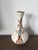 A small flared mouth vase by Raine, New Mexico, featuring a hand-painted Corn Maiden Kachina motif with a turquoise stone...