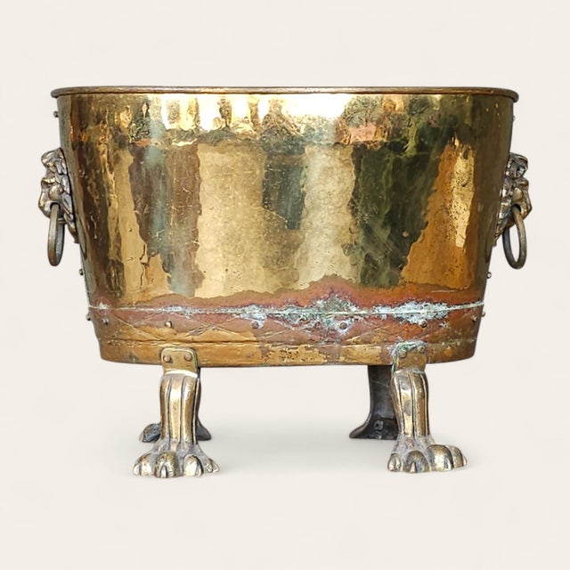 Victorian English brass jardiniere dating to the 19th century, raised on four cast lion’s paw feet and fitted with applied...