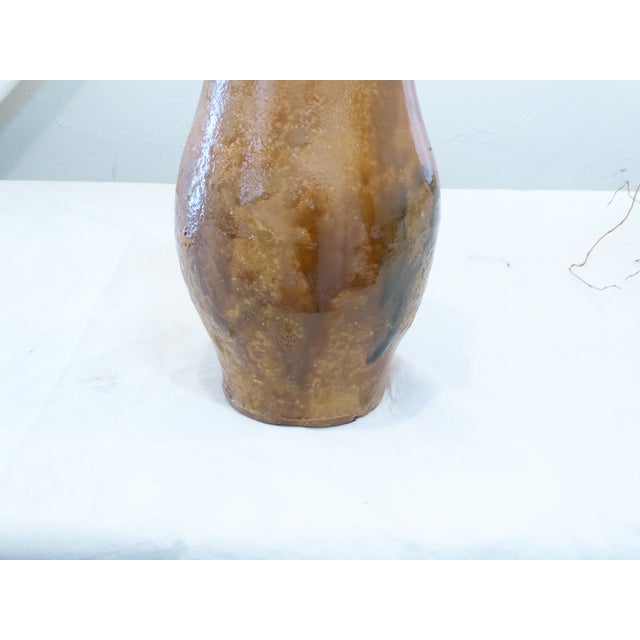 This hand thrown glazed terra cotta vase has gradiations of colors. It is 16"H x 8"Diameter