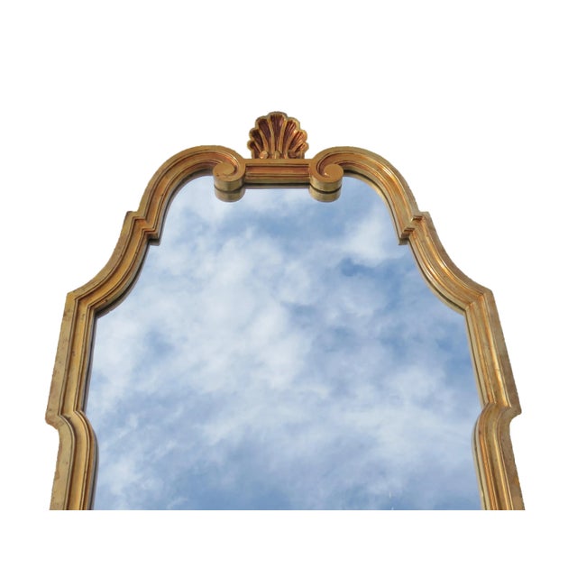 A lovely vintage neoclassic gold wall mirror with shell crest. Made of resin, finished in bright gold paint. Attributed to...