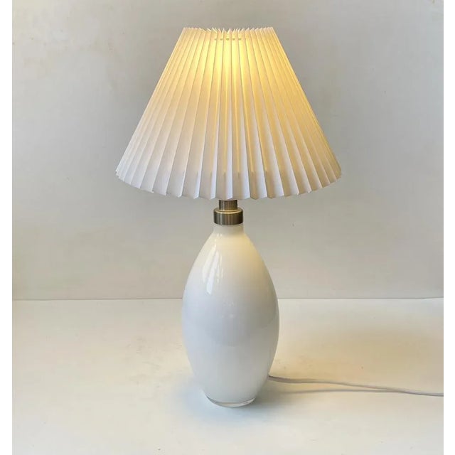 Stylish hand-blown table lamp in white opaline glass. Designed by Peter Svarrer and manufactured by Holmegaard in Denmark...