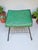 This Retro 1950s Mid-Century footstool with a magazine rack features a green vinyl top and a metal base, making it a...