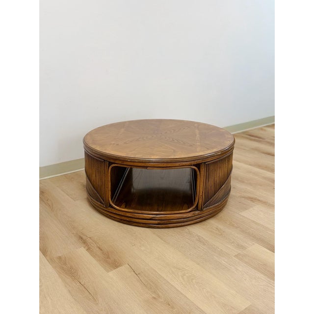 This gorgeous vintage pencil reed rattan round coffee table with burlwood inlay is a rare and beautifully crafted...