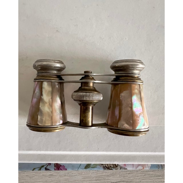 A beautifully detailed pair of antique French opera glasses by Sportiere, featuring luminous mother-of-pearl panels set...