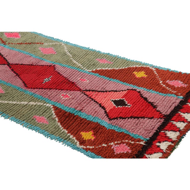 Hand-knotted in wool and originating from Morocco circa 1950-1960, this 3x7 vintage Moroccan rug is an extremely rare...