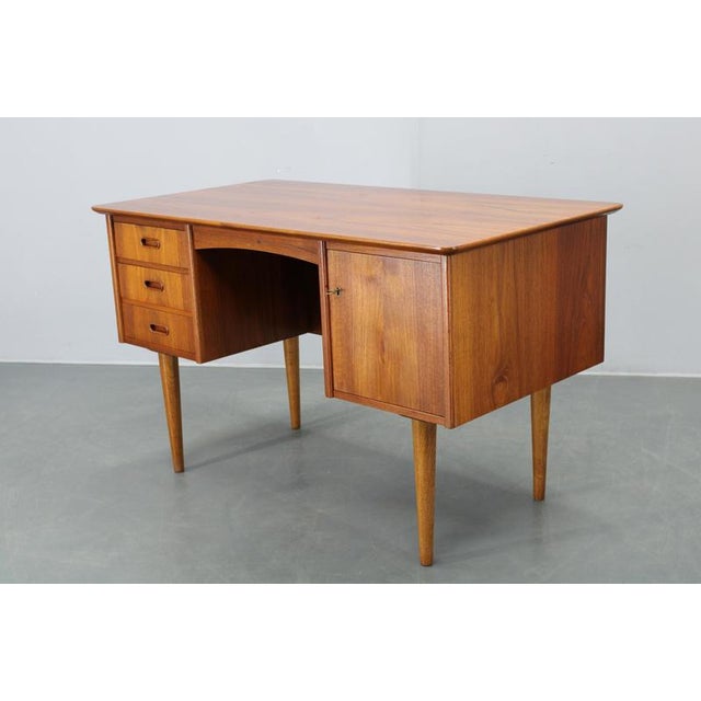 This danish mid-century modern writing desk dates from the 1960s and exemplifies the functional elegance and craftsmanship...