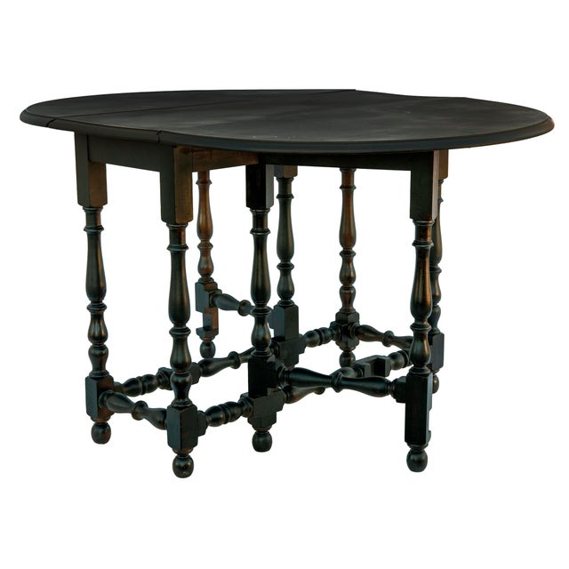 Handsome 20th century mahogany compact drop leaf table in mahogany with a black lacquered finish.