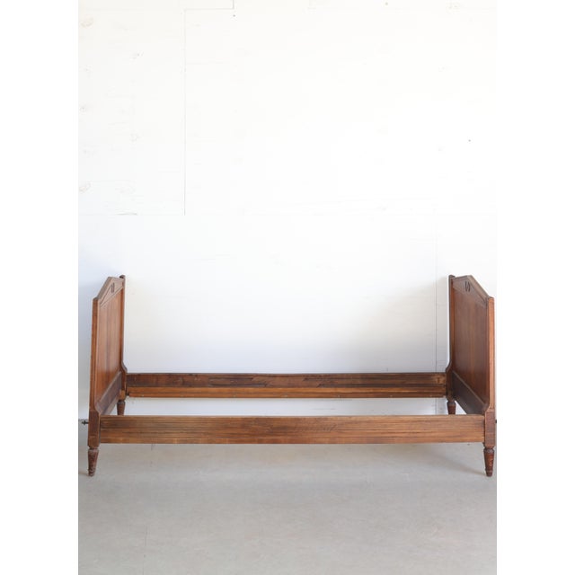 A graceful 19th-century Louis XVI style daybed, embodying the refined neoclassical elegance of the era. Crafted with a...