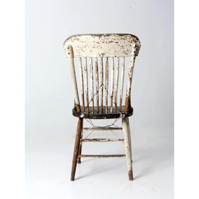 This antique spindle back chair reflects classic farmhouse craftsmanship with its simple lines and sturdy construction....