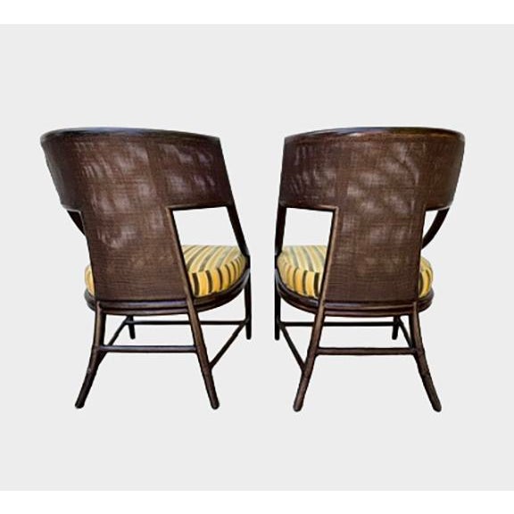A pair of classic curved arm chairs designed by Barbara Barry for The Mcguire Company. Finish: Dark Tobacco Fabric:...