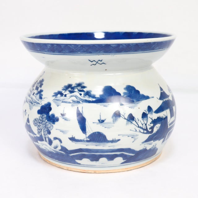 A fine antique Chinese porcelain spittoon. In the Canton pattern. Decorated in underglaze blue with a mountainous Chinese...